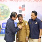 Pj Bupati Azwardi memasang PIN kepada Keuchik Pasi pinang sebagai desa terpilih untuk pilot projek desa bebas korupsi
Foto Dok. Diskominsa